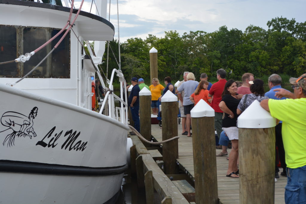 "Lil Man" at dock with long line of customers at right side.
