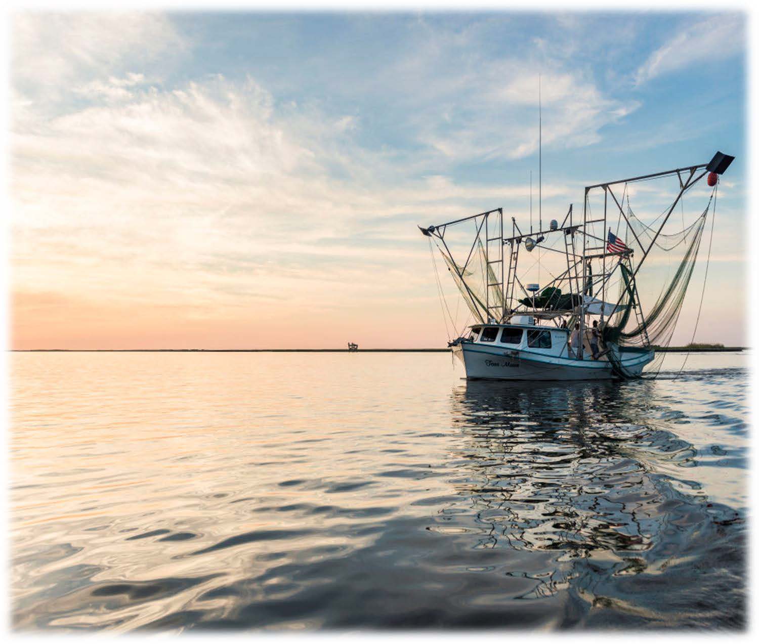 shrimp boat on water at sunset