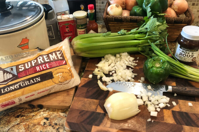 gumbo ingredients like celery, onion, and rice on cutting board