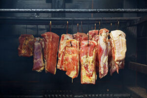 Hanging ham in the smokehouse smoked bacon for smoking