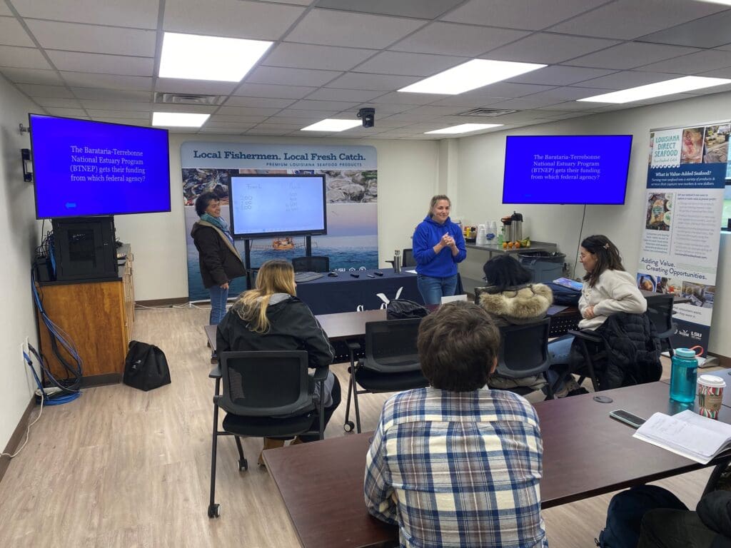 people seated in a training room with Audio/visual equipment and 2 presenters