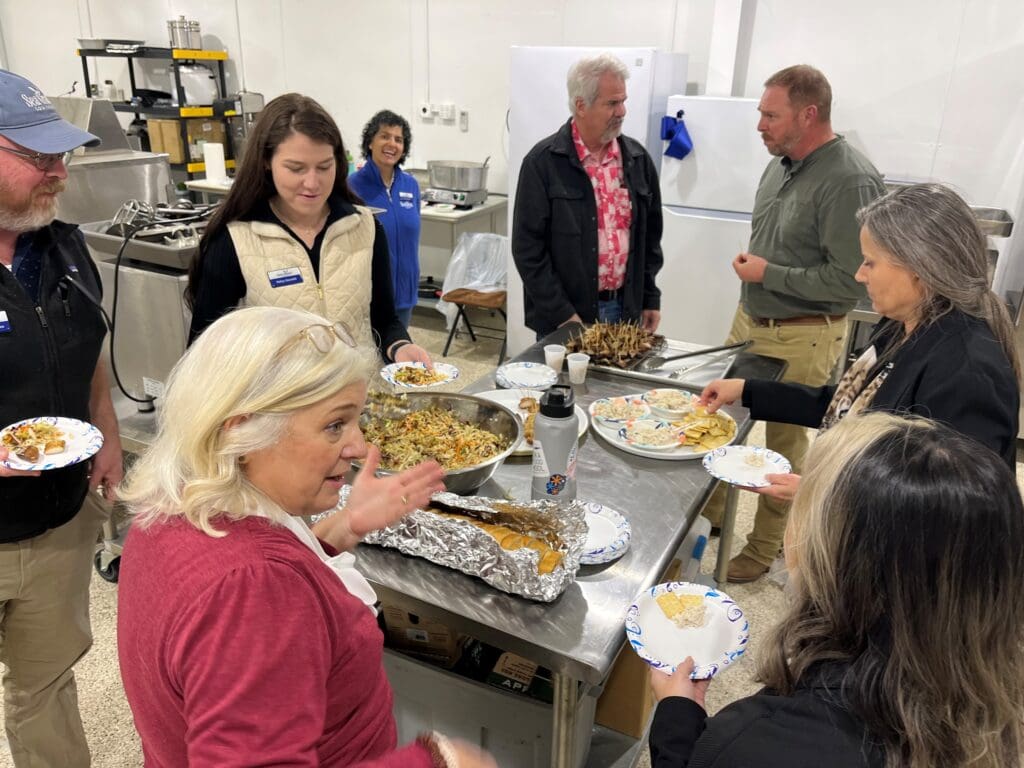 people serving themselves from a table with food items