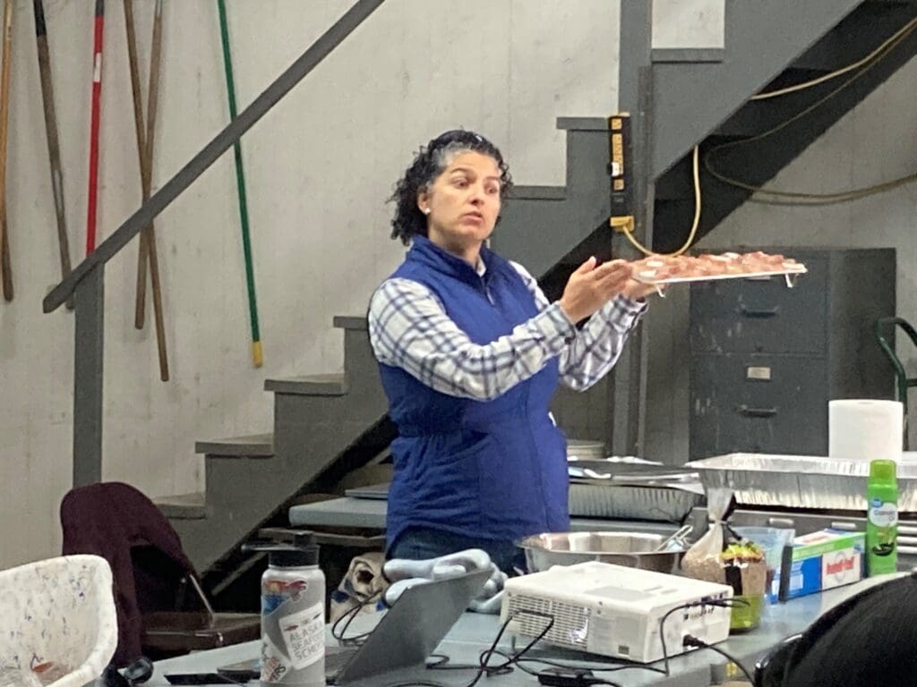 Female with tray of fish parts presenting cooking methods